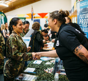 An employer shaking hands with a trainee at an employer expo