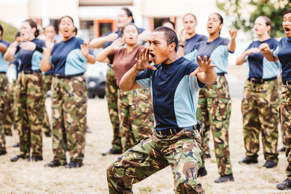 A group of LSV trainees in uniform perform a haka at their graduation.